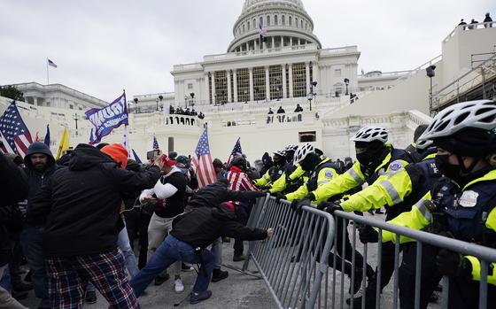 FILE - Insurrectionists loyal to President Donald Trump try to break through a police barrier, Wednesday, Jan. 6, 2021, at the Capitol in Washington.  (AP Photo/Julio Cortez, File)