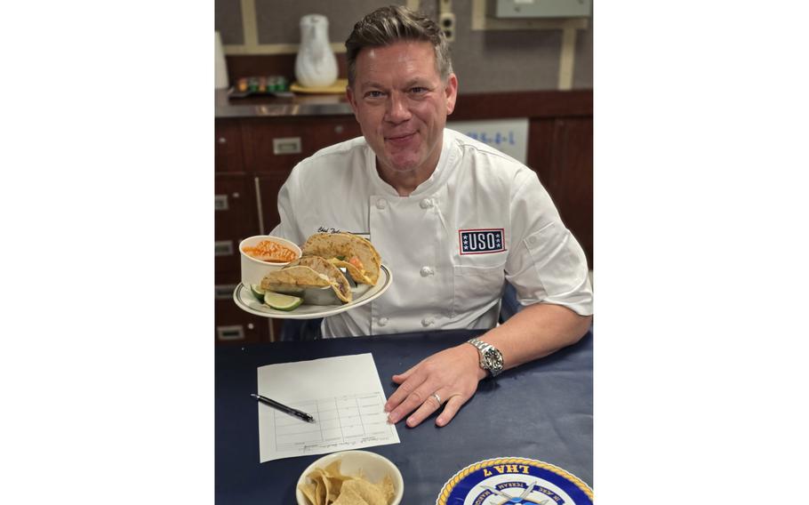 Chef Tyler Florence holds  a plate of tacos