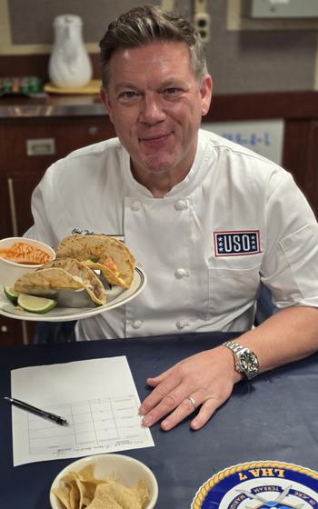 Chef Tyler Florence holds  a plate of tacos