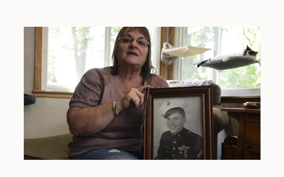 Nita Kay holds a photo and dog tags of her uncle, World War II veteran Marine Sgt. Arthur Ervin at her home in Chisago City, Minn., on July 3, 2024. 