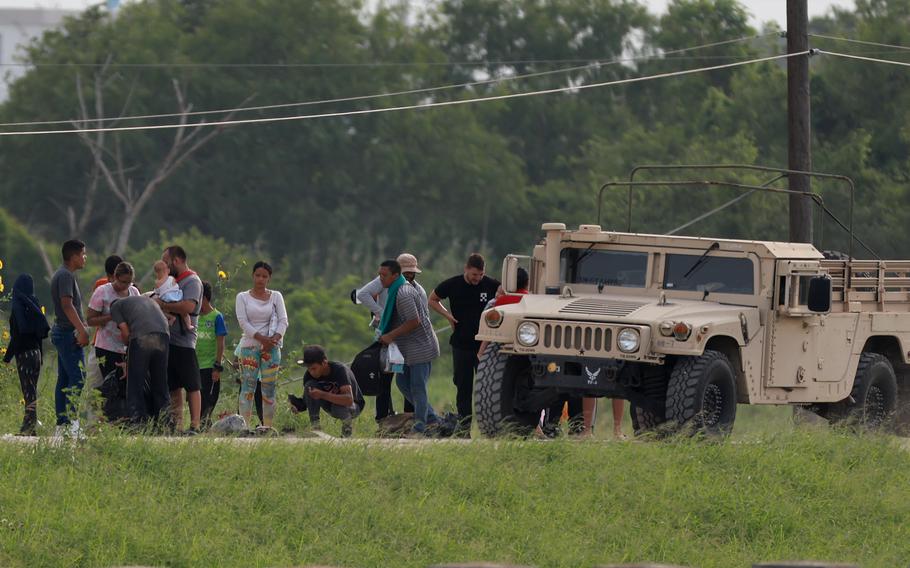 Migrants stand in line as they await processing by the U.S. Border Patrol after crossing the border from Mexico on May 10, 2023, in Brownsville, Texas. 