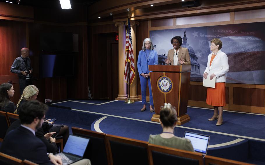 Lauren Underwood speaks at a lectern. Jeanne Shaheen stands next to her.