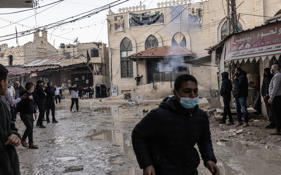 Palestinians react during clashes between Palestinian Authority security forces and the militants who control the Jenin refugee camp Monday in the Occupied West Bank. MUST CREDIT: Heidi Levine for The Washington Post