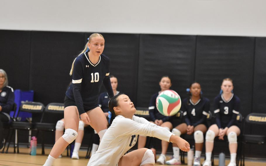 Black Forest Academy libero Esther Lee bumps the ball while teammate Priscilla Sivonen watches Friday, Sept. 13, 2024, in the Falcons' four-set victory over Naples in Vicenza, Italy.