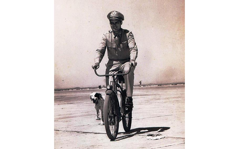 Brig. Gen. Robert Travis rides his bike to work followed by his dog, Dan, at Fairfield-Suisun Air Force Base in California. Travis was killed when his B-29 Superfortress crashed on Aug. 5, 1950. The base was renamed in his honor one year later.