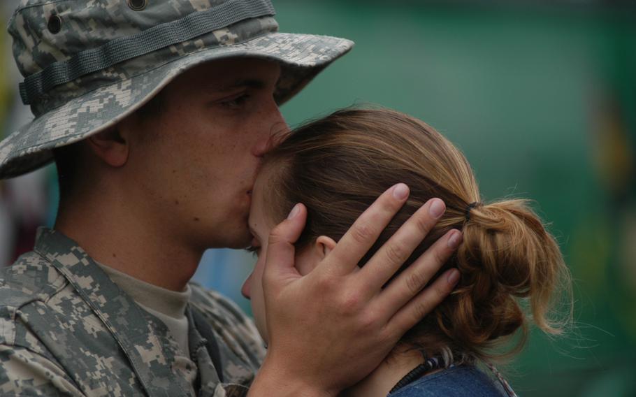 Spc. Matthew Clark, 23, kisses his wife, Sandra Rossa, 21, moments before boarding a bus Monday. Soon after, Clark and more than 200 other members of his unit, the 596th Maintenance Company, left on the first leg of their journey to Iraq for a yearlong tour. Clark and Rossa married two months ago and expect their first child in March 2007. Rossa said she was thinking the same thing everyone else was thinking as the troops loaded on buses: “I hope they all come back,” she said.