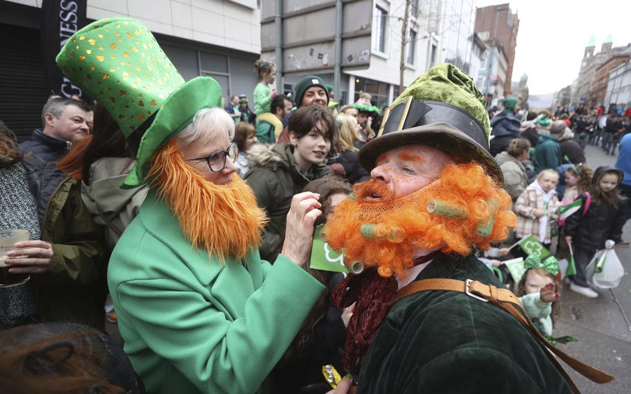 Two men wear orange beards and green costumes and hats.