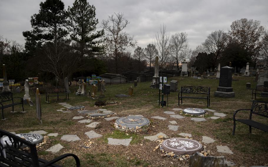 A cemetery with gravestones on one side and flat circles on the other.