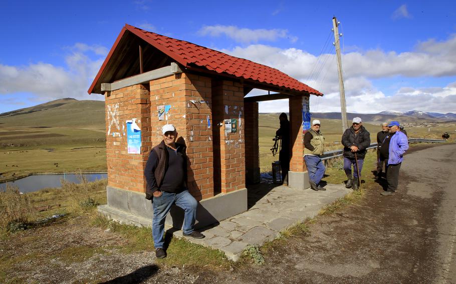 A few men wait at a bus stop in a rural area in Georgia’s Javakheti region, Oct. 22, 2024. 