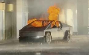 Flames rise out of the top and sides of a Tesla Cybertruck parked on a street.