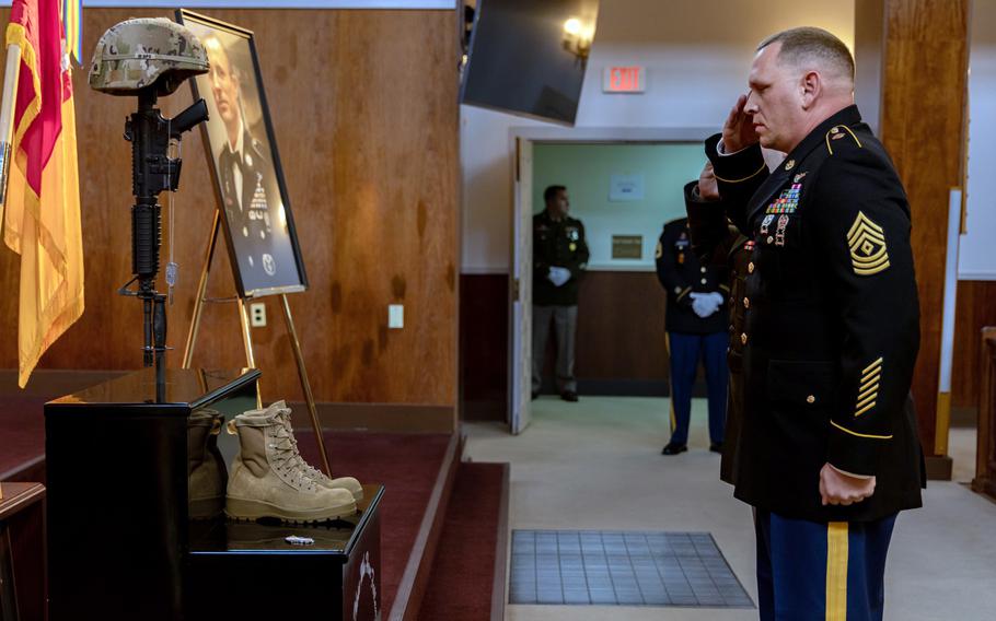 A soldier salutes at a memorial display for Master Sgt. Justin Sweat at the Camp Zama Chapel. 