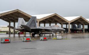 An F-22 taxis at Kadena Air Base Okinawa with a gray sky overhead.