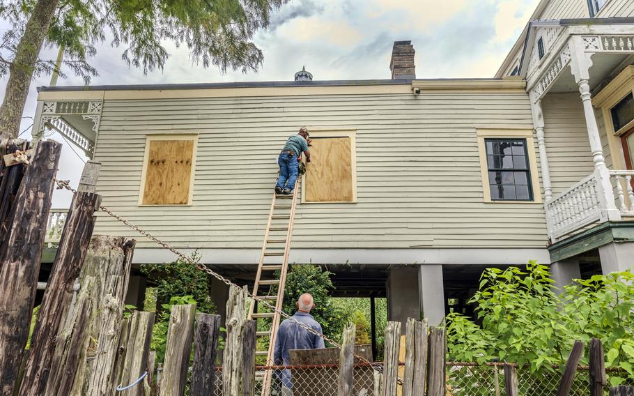 Residents board up windows of a raised historic house in Lafitte, La., on Sept. 9, 2024, as they prepare for the arrival of Tropical Storm Francine.