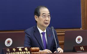 South Korean Prime Minister Hand Duck-Soo sitting at a desk.