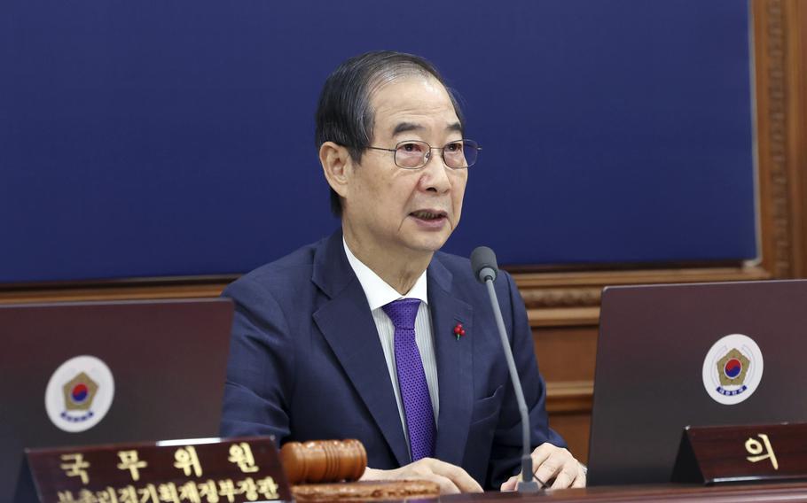 South Korean Prime Minister Hand Duck-Soo sitting at a desk.