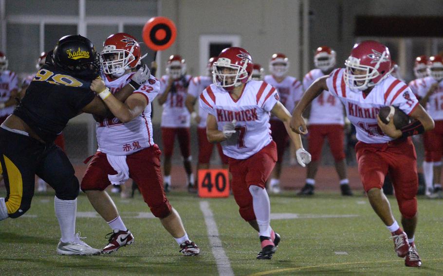 Kinnick quarterback Atsushi Blocton gets an escort from Red Devil running back Derek Ulrich.