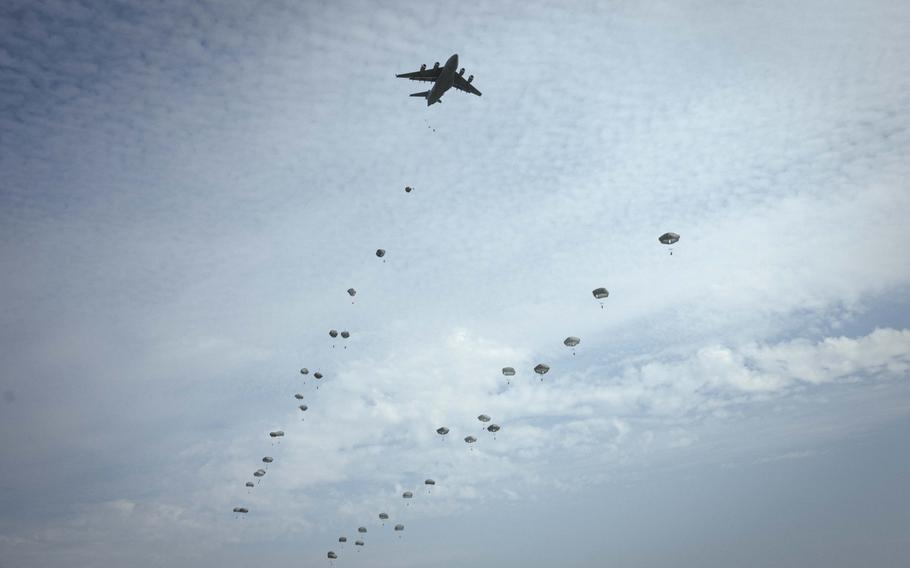 Soldiers with the 173rd Airborne Brigade parachute out of C-17 Globemaster III and C-130 Hercules aircraft to a field outside of the Joint Multinational Readiness Center Hohenfels Training Area, Germany, for Exercise Saber Junction on Sept. 4, 2024. The annual exercise in Bavaria tested U.S. and NATO troops in joint operations, with a focus on airborne tactics and lessons learned from Russia's war with Ukraine.