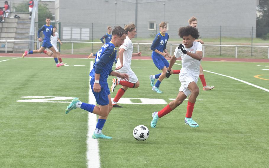 Kaiserslautern's Gabe Urquhart tries to stay in front of Wiesbaden's Sean Heeter during a Warrior attack Monday, May 20, 2024, in the opening day of the DODEA European Division I boys soccer championships at Kaiserslautern High School in Germany.
