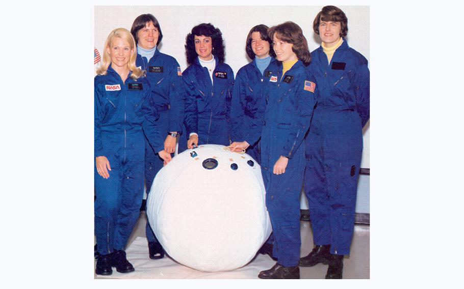 NASAs first six women astronauts pose with a mockup of a personal rescue enclosure or “rescue ball” in the crew systems laboratory at the Johnson Space Center in December 2009