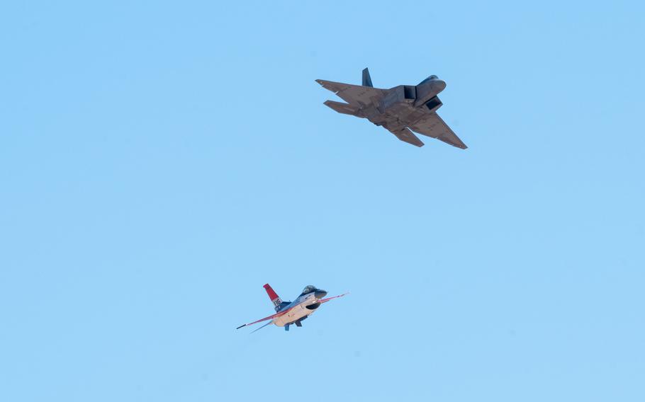 Two aircraft fly together under a blue sky.