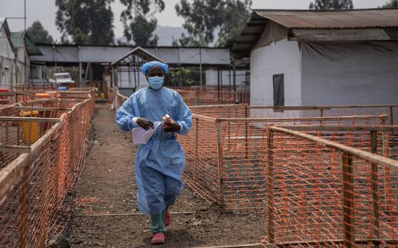 A health worker walks past a mpox treatment centre in Munigi, eastern Congo, Friday, Aug. 16, 2024. (AP Photo/Moses Sawasawa)