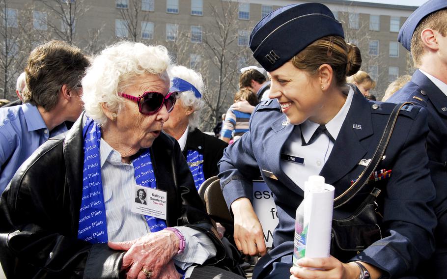 An older woman talks to a younger woman in uniform.