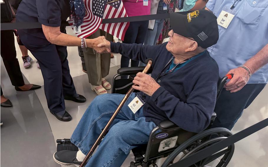 A well-wisher shakes the hand of World War II veteran Bill Kelly Jr. on Friday, May 31, 2024, at Dallas-Fort Worth.