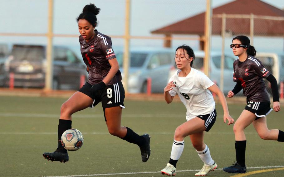 Nile C. Kinnick's Alyssa Staples moves the ball upfield ahead of teammate Annabelee Hernandez and Robert D. Edgren's Kaleiana Alonzo during Friday's DODEA-Japan girls soccer match. The Red Devils won 11-0.