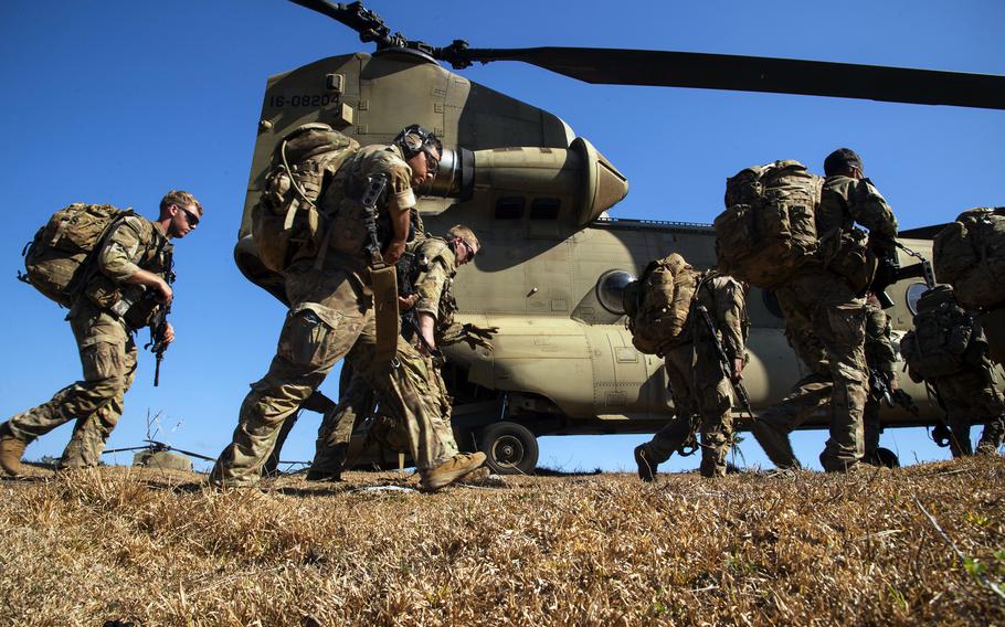 Soldiers with the 25th Infantry Division walk toward a CH-47F Chinook helicopter