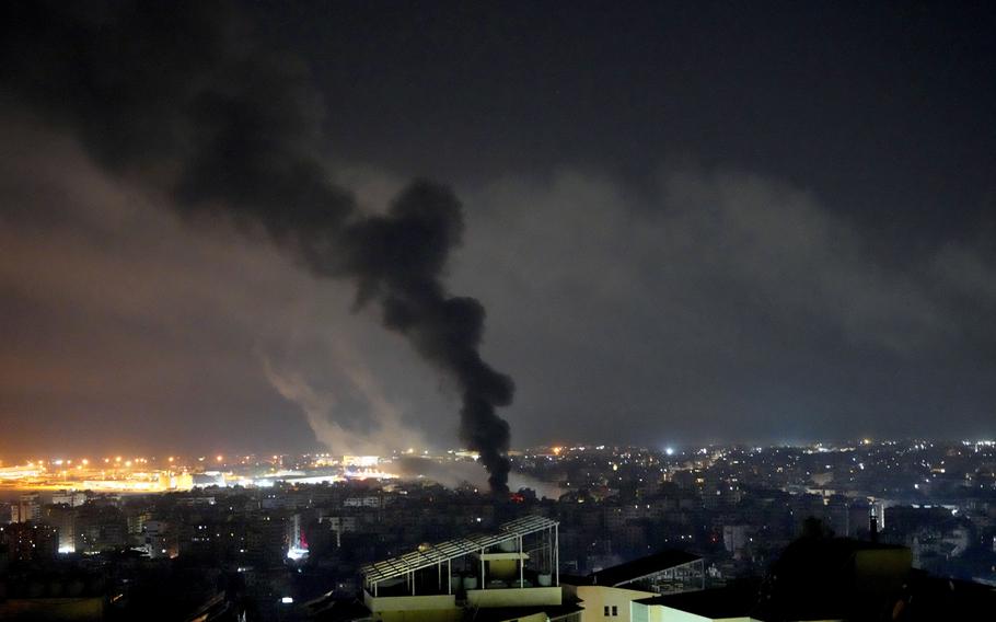 A night view of Beiruit’s southern suburbs shows a funnel of black smoke.