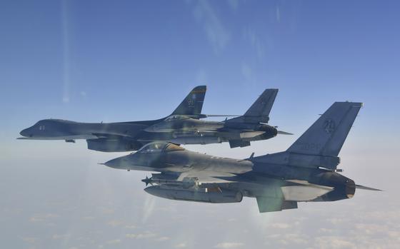 Two U.S. F-16 Fighting Falcons fly alongside a B-1B Lancer