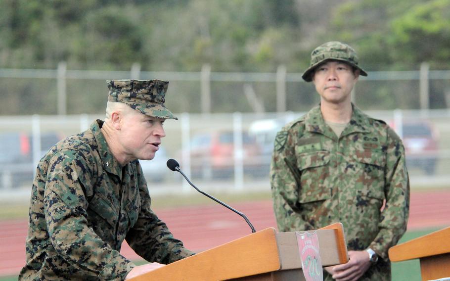 Brig. Gen. Trevor Hall talks into a microphone alongside a Japanese major general.