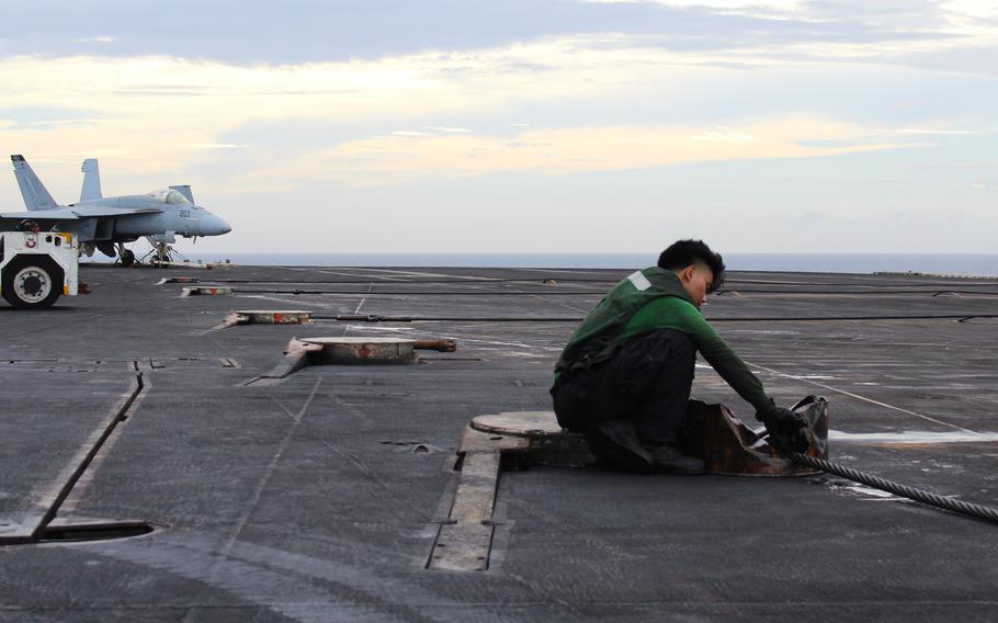 A sailor prepares the arresting cables onboard the USS Dwight D. Eisenhower to be put into storage July 13, 2024, as the aircraft carrier returned to its homeport of Norfolk Naval Station in Virginia.