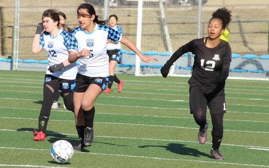 Osan’s Camrynn Tuigamala drives upfield againsts Daegu’s Samantha Jones during Friday’s Korea girls soccer match. The Cougars won 5-2.