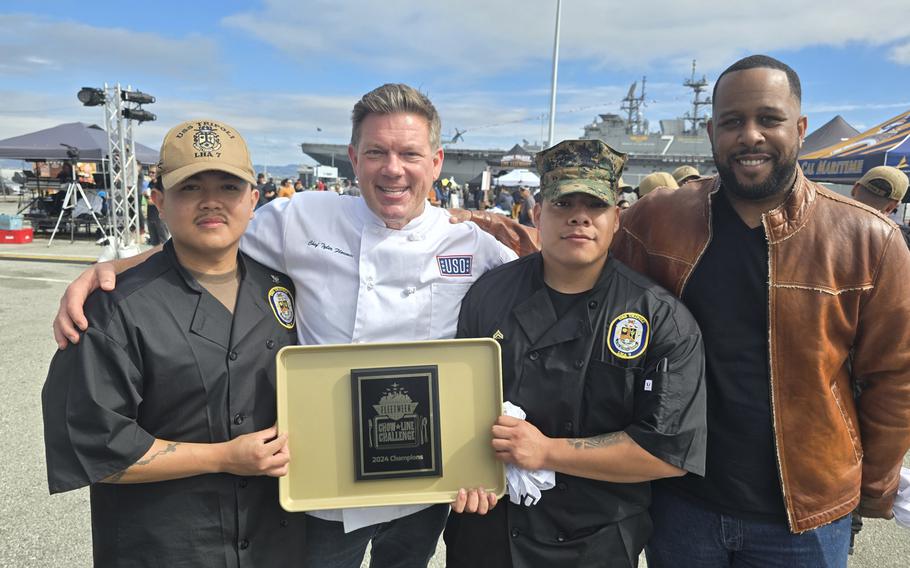 CS3 Calvin Dion, from Lapeer, Mich., left, and Cpl. Jonathan Santos, from Anaheim, Calif., center right, hold a winning plaque 