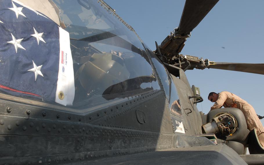 An American flag sitting in the cockpit of an Apache helicopter