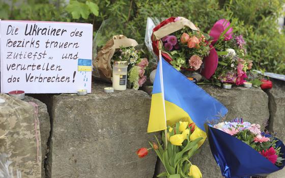 Flowers and a small Ukrainian flag are laid at a shopping center in Murnau, Germany, Sunday, April 28, 2024.