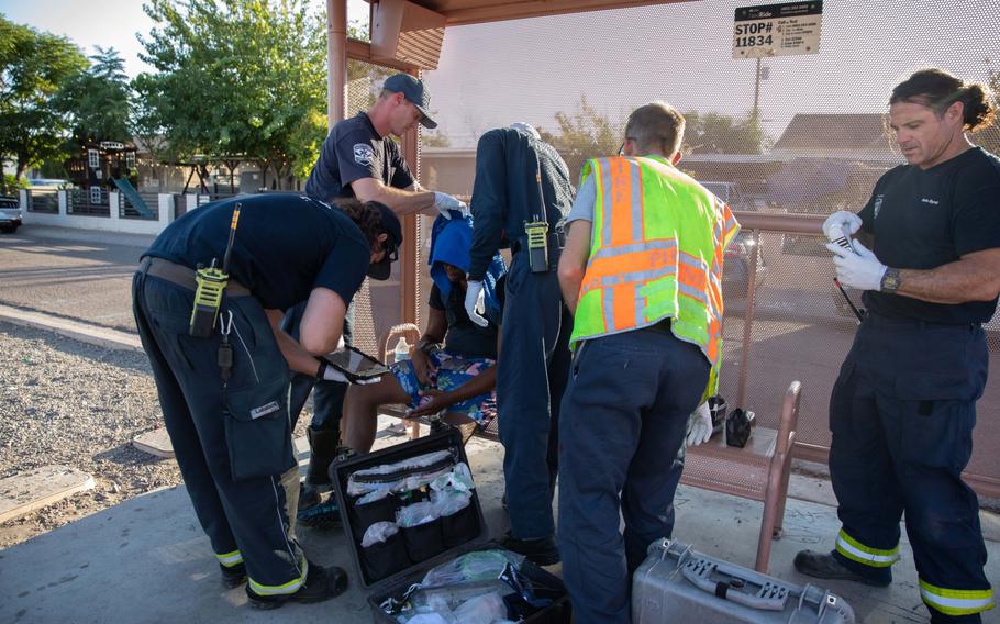 Firefighters assist a resident during a heat wave in Phoenix on July 20, 2023. 