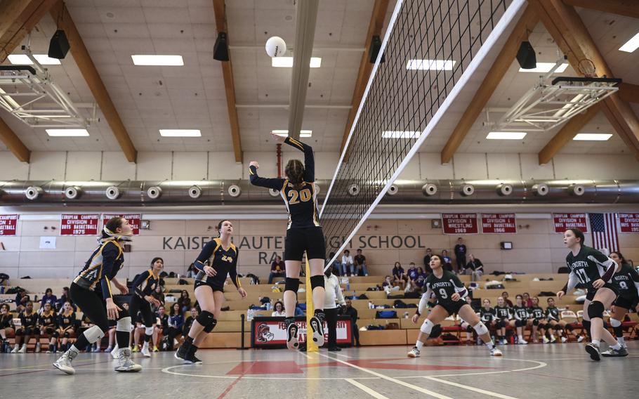 Ansbach Cougar Natalie Ritter soars to spike the ball across the net, while AFNORTH Lions Sophia Mier and Isabella Guest position themselves defensively during the DODEA Division III European volleyball semifinals on Oct. 27, 2023, in Kaiserslautern, Germany.