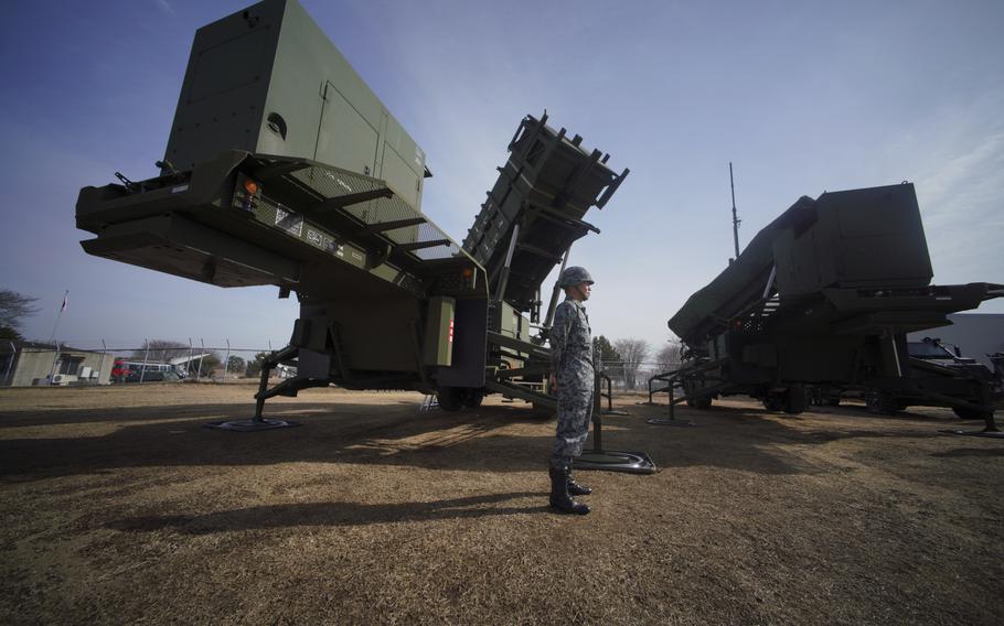A member of the Japan Ground Self-Defense Force stands guard next to a surface-to-air Patriot Advanced Capability-3 missile interceptor launcher vehicle in Funabashi, east of Tokyo, on Jan. 18, 2018. 