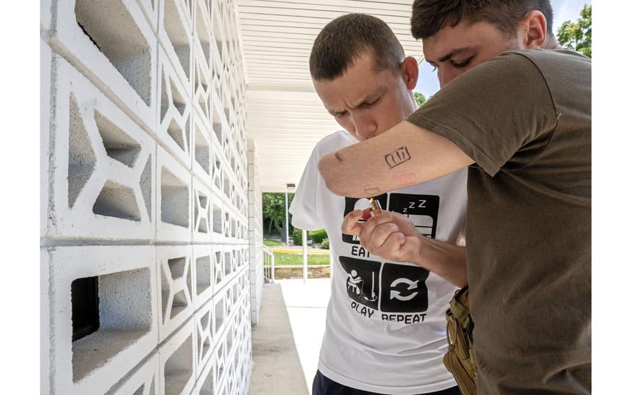 Ilia Mykhalchuk, left, has his cigarette lit for him by Denys Stratiishuk during a break from being fitted for prosthetics. 