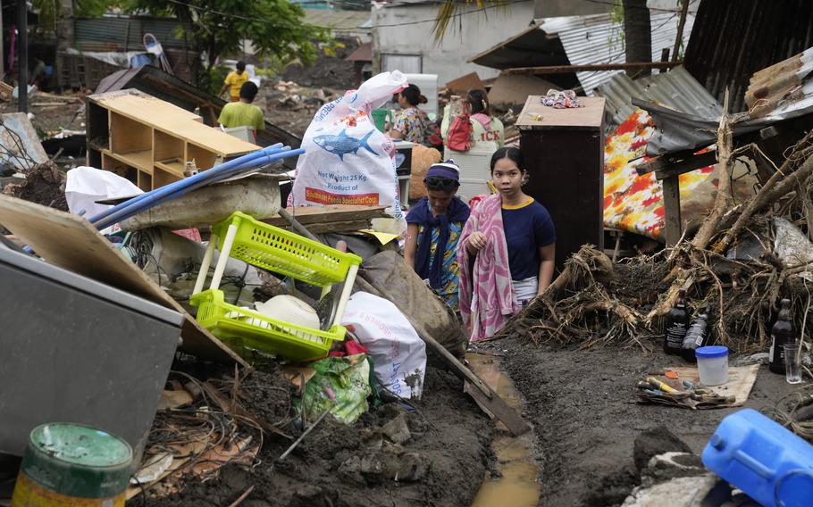 Residents try to recover belongings from their damaged homes after a recent landslide triggered by Tropical Storm Trami struck Talisay, Batangas province, Philippines, leaving thousands homeless and several villagers dead on Saturday, Oct. 26, 2024.