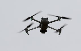 A camera-equipped drone hovers in the air.