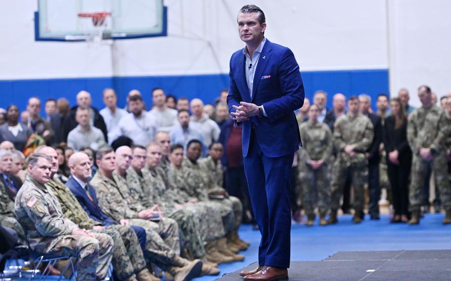 Pete Hegseth is standing with soldiers sitting in the background