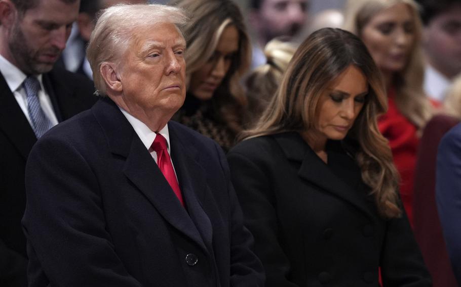 Donald and Melania Trump bow their heads.