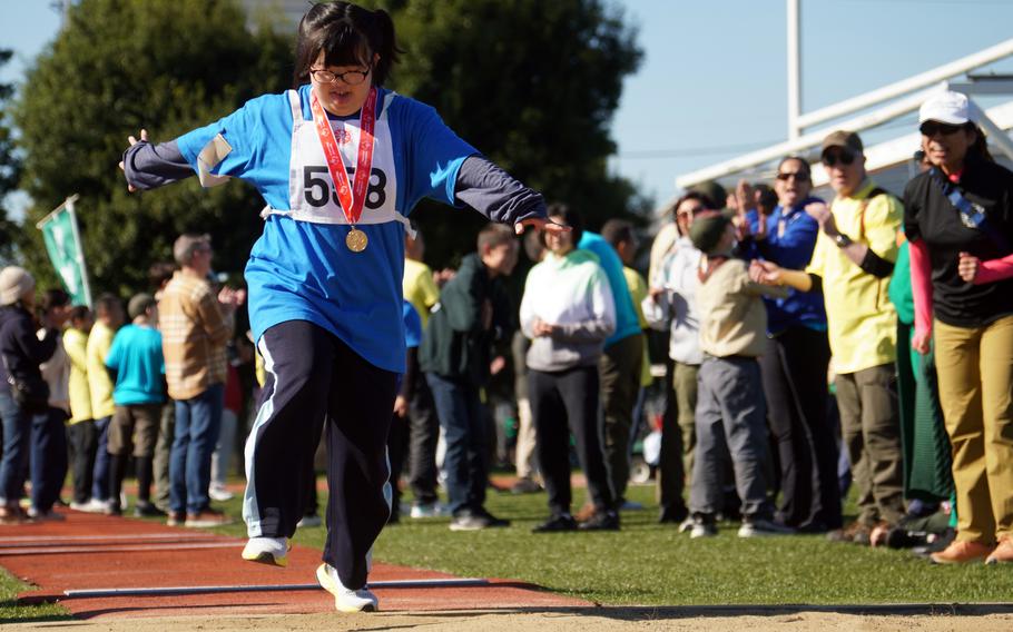 An athlete wearing a medal jumping.