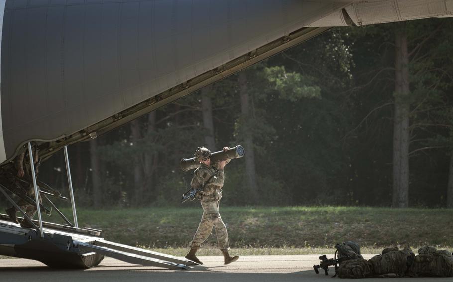 A U.S. soldier participating in exercise Saber Juntion carries a weapon off a C-130 at the Joint Multinational Readiness Center in Germany on Sept. 5, 2024. The cargo plane landed on a runway that was restored just ahead of the exercise.