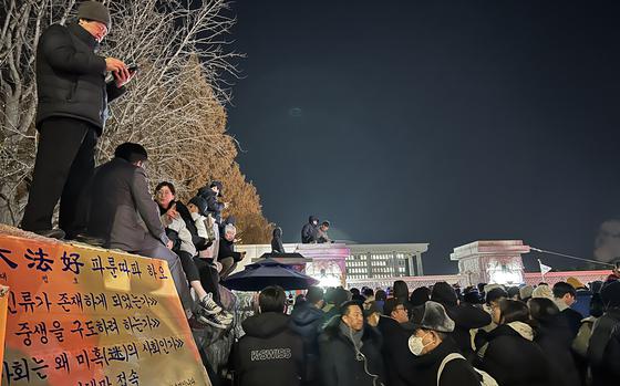 Activists and observers gather around a gate leading to the National Assembly building in Seoul, South Korea, Dec. 4, 2024.