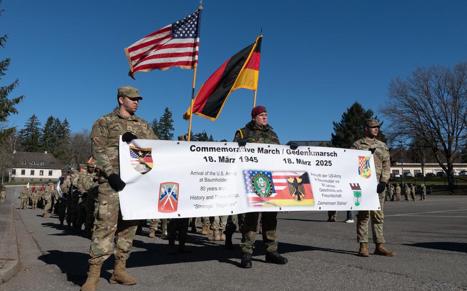 U.S. and German soldiers hold a banner during a parade together