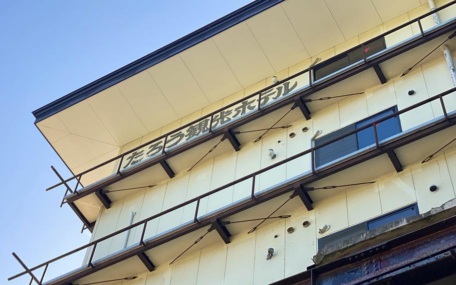 The damaged facade of a former hotel is seen from below.